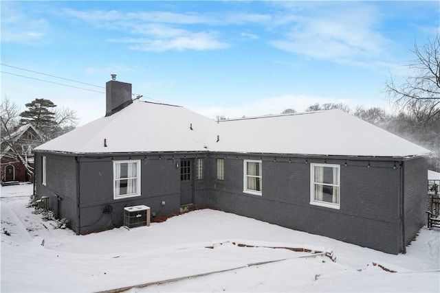 snow covered rear of property with central AC