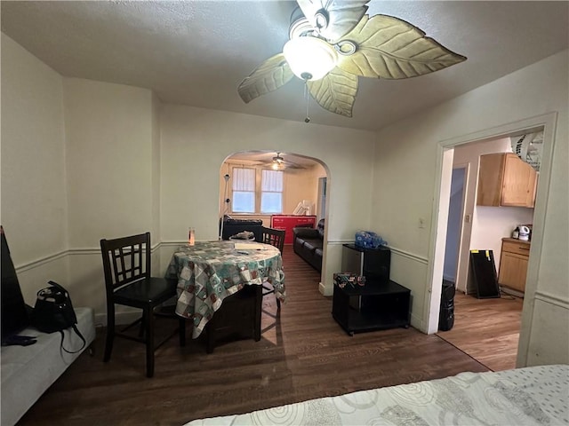 dining space with ceiling fan and dark wood-type flooring