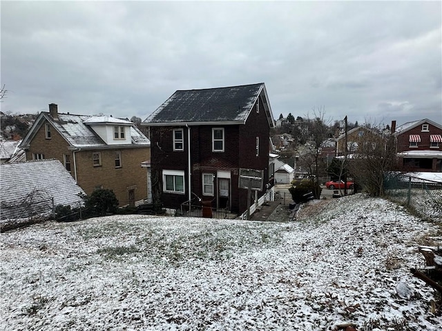 view of snow covered rear of property