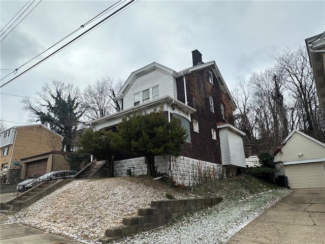 view of home's exterior featuring a garage and an outbuilding