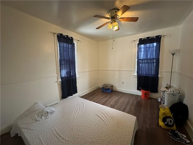 bedroom with dark hardwood / wood-style floors and ceiling fan