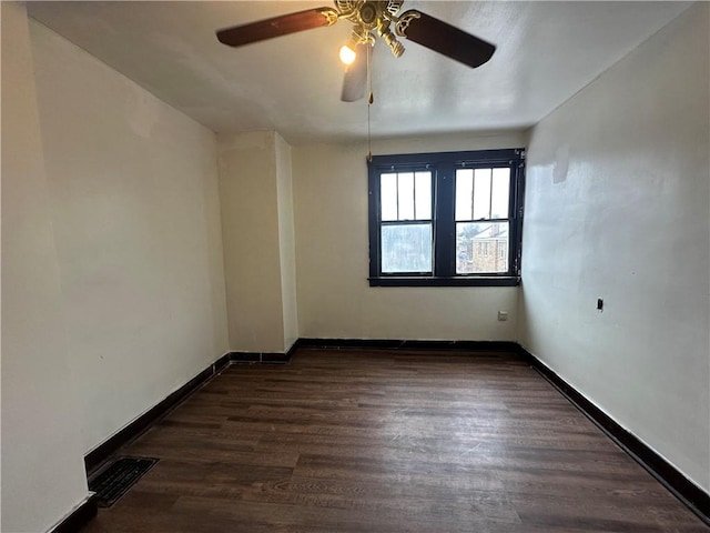 spare room with ceiling fan and dark hardwood / wood-style floors