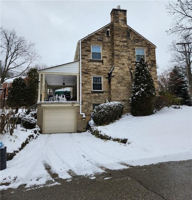 snow covered property with a garage