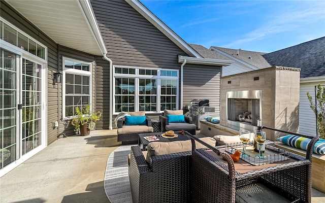 view of patio / terrace with an outdoor living space with a fireplace and grilling area