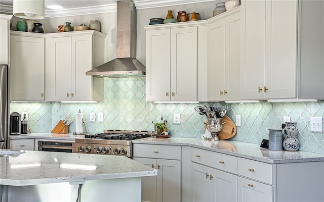 kitchen featuring white cabinets, decorative backsplash, and wall chimney exhaust hood