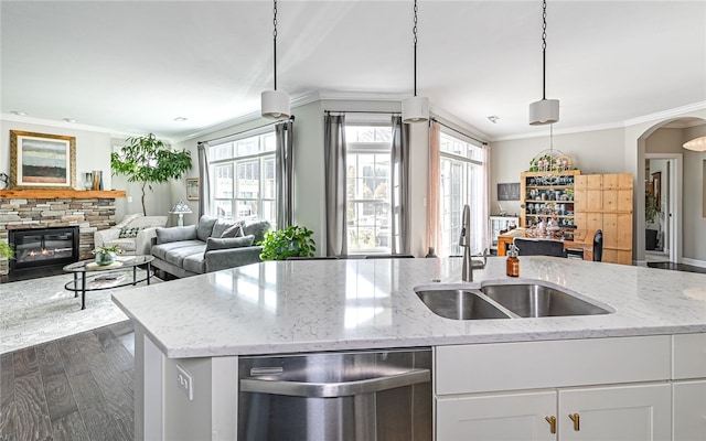 kitchen featuring dishwasher, sink, hanging light fixtures, light stone countertops, and white cabinetry