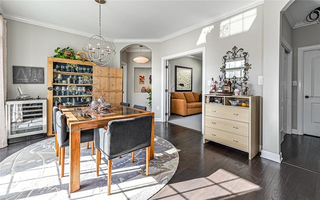 dining area featuring dark hardwood / wood-style floors, crown molding, beverage cooler, and a notable chandelier