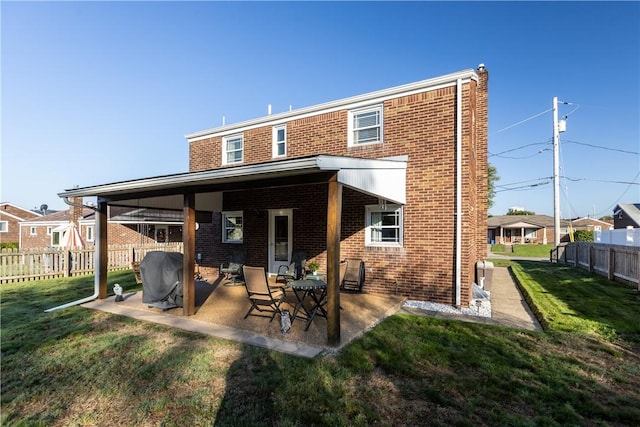 back of house featuring a patio and a lawn