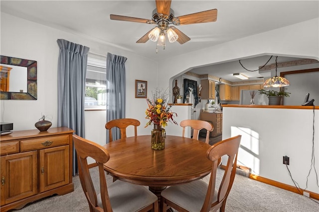 carpeted dining area with ceiling fan