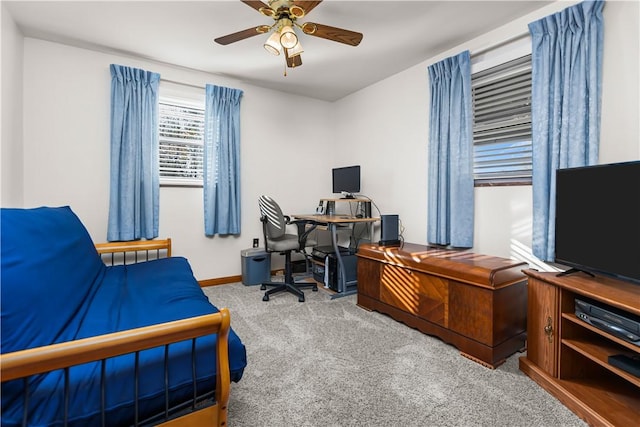 carpeted home office featuring ceiling fan