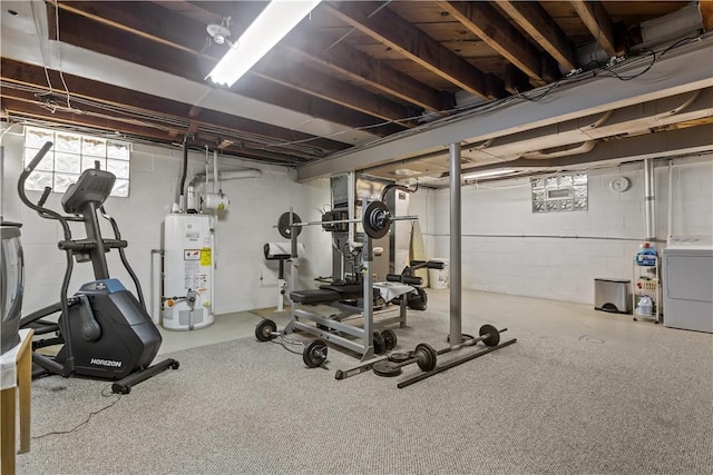 exercise room featuring water heater and washer / dryer