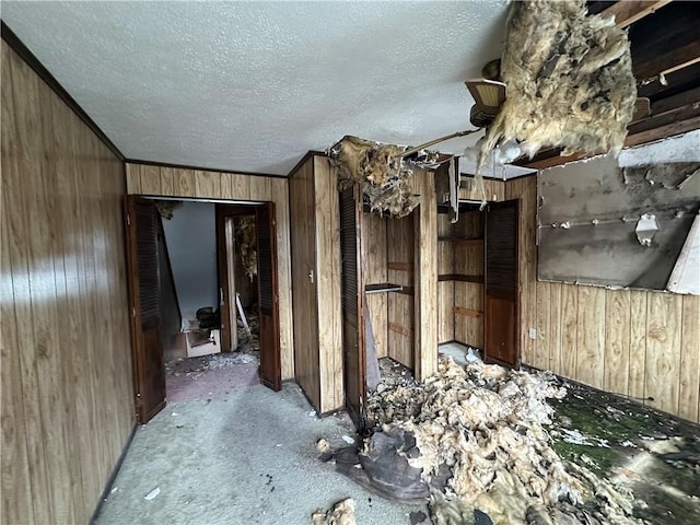 misc room with a textured ceiling and wooden walls