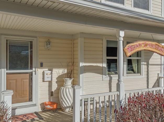 view of exterior entry featuring covered porch