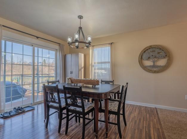 dining space featuring dark hardwood / wood-style floors and a chandelier