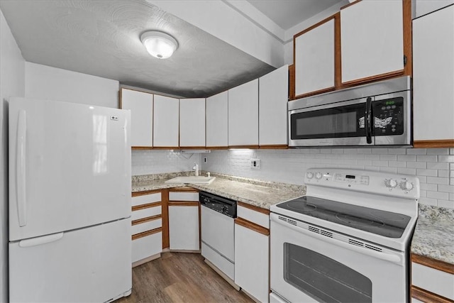 kitchen featuring white appliances, white cabinets, sink, decorative backsplash, and light hardwood / wood-style floors