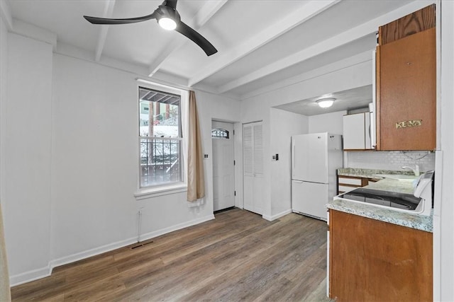 kitchen with backsplash, ceiling fan, sink, white refrigerator, and hardwood / wood-style flooring