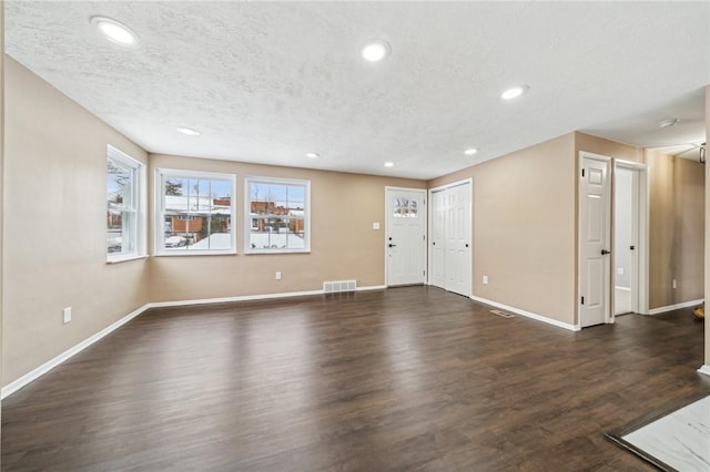 interior space with dark wood-type flooring and a textured ceiling