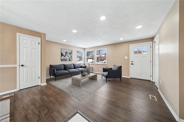 living room with dark hardwood / wood-style floors and a textured ceiling