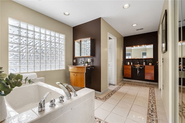 bathroom featuring tile patterned flooring, vanity, and a tub to relax in