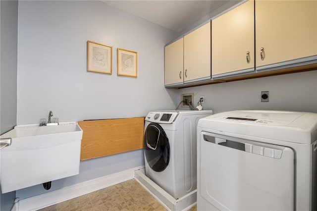 laundry room with cabinets, washing machine and dryer, and sink