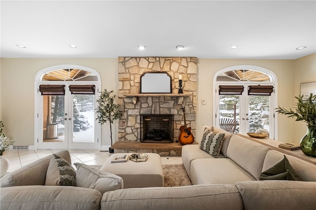 living room featuring a fireplace, french doors, and light tile patterned floors