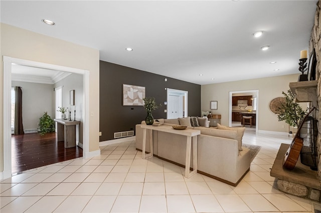 tiled living room featuring crown molding and a fireplace