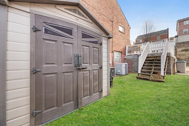 view of outdoor structure with a yard and central AC