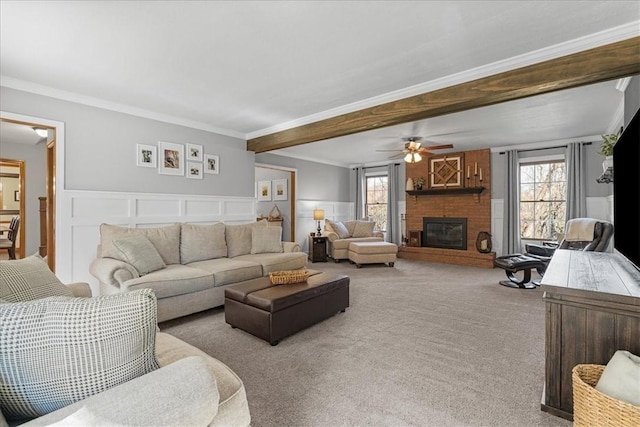 carpeted living room with plenty of natural light, ceiling fan, ornamental molding, and a brick fireplace