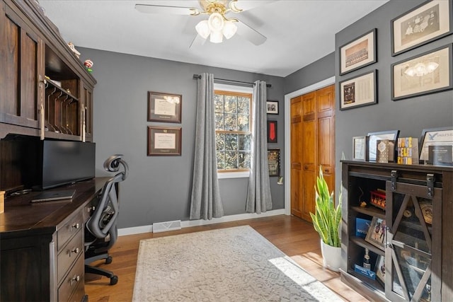 office area with light wood-type flooring and ceiling fan