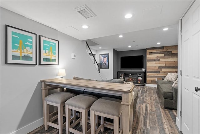 bar with dark wood-type flooring and wooden walls