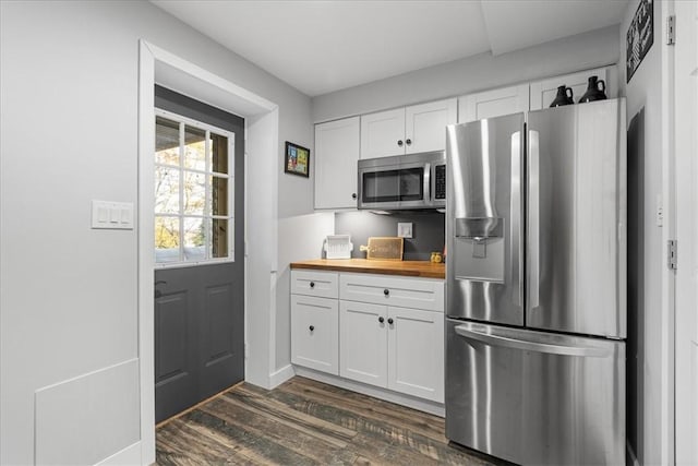 kitchen featuring white cabinets, dark hardwood / wood-style flooring, butcher block counters, and appliances with stainless steel finishes