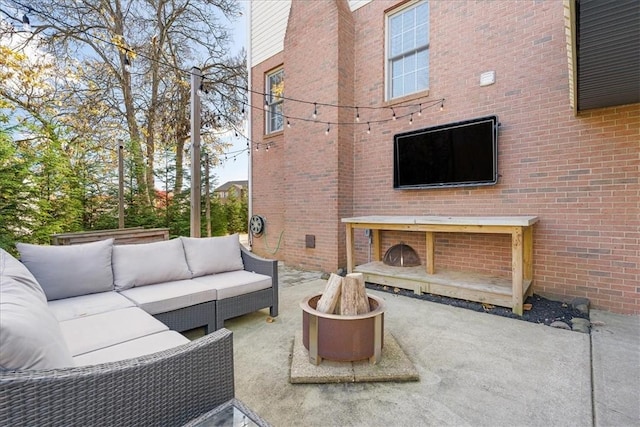 view of patio with an outdoor living space with a fire pit