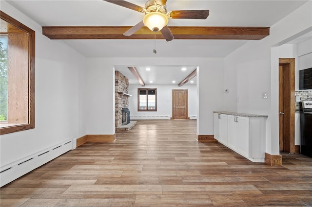 unfurnished living room with baseboard heating, ceiling fan, beam ceiling, and light wood-type flooring