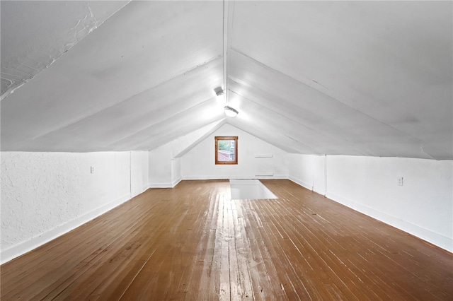 additional living space with hardwood / wood-style flooring and lofted ceiling