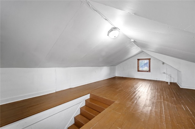 additional living space with hardwood / wood-style flooring and vaulted ceiling