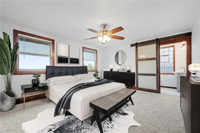 bedroom with ceiling fan and a barn door