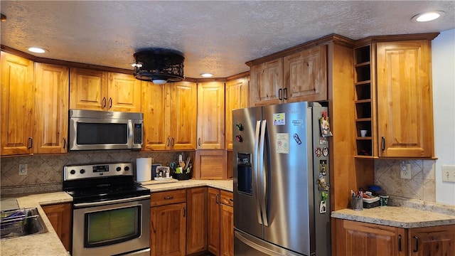 kitchen featuring tasteful backsplash, sink, and appliances with stainless steel finishes