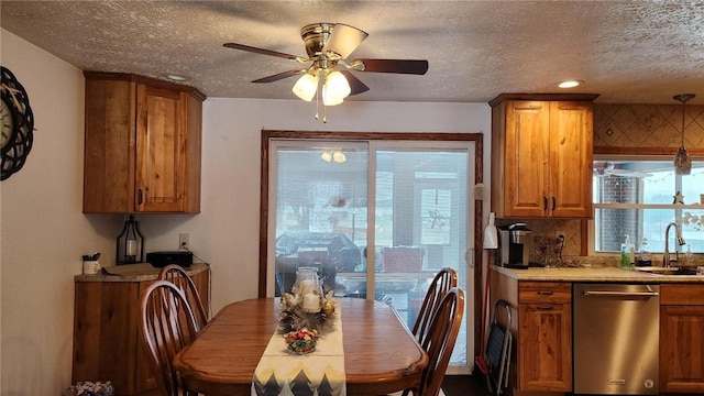 dining area featuring a textured ceiling, ceiling fan, and sink