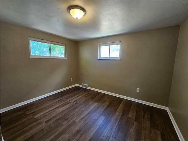 empty room with dark hardwood / wood-style flooring