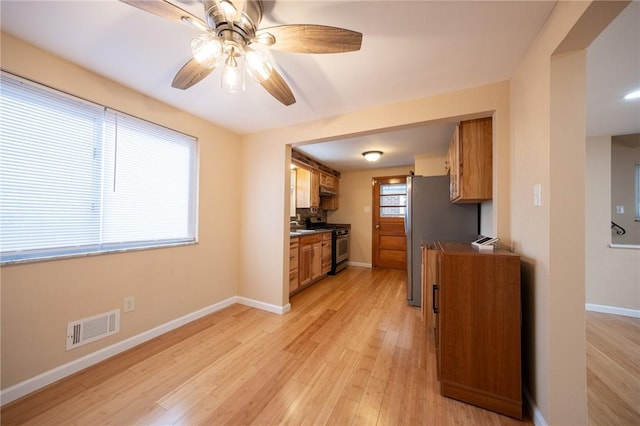 kitchen featuring ceiling fan, appliances with stainless steel finishes, and light wood-type flooring