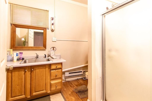 bathroom featuring baseboard heating, hardwood / wood-style floors, vanity, and an enclosed shower