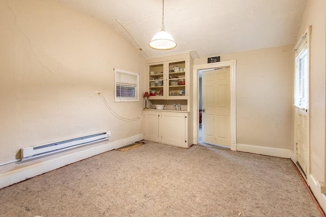 carpeted spare room with a baseboard radiator and vaulted ceiling