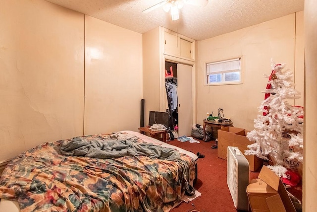 carpeted bedroom with ceiling fan and a textured ceiling