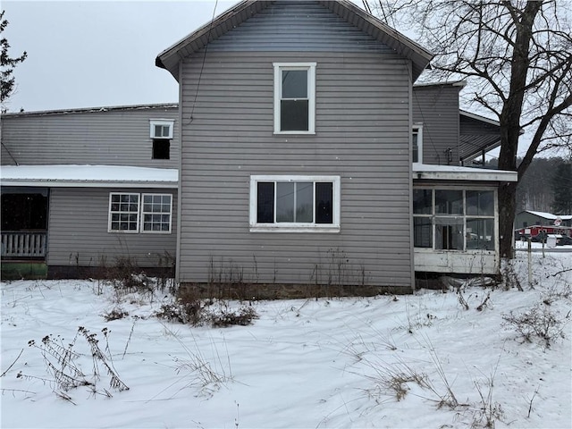 snow covered property featuring a sunroom