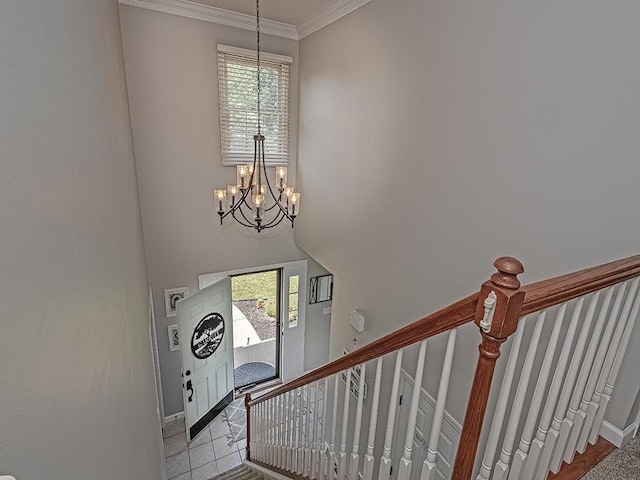 stairway with tile patterned flooring, crown molding, a wealth of natural light, and a notable chandelier