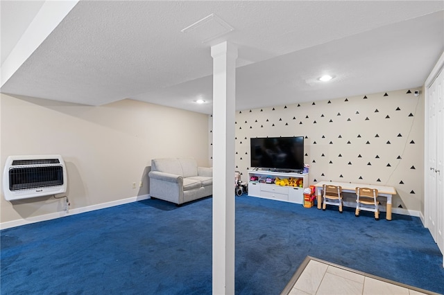 game room with heating unit, dark carpet, and a textured ceiling