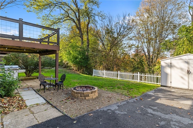 view of yard with a fire pit, a patio area, a shed, and a deck