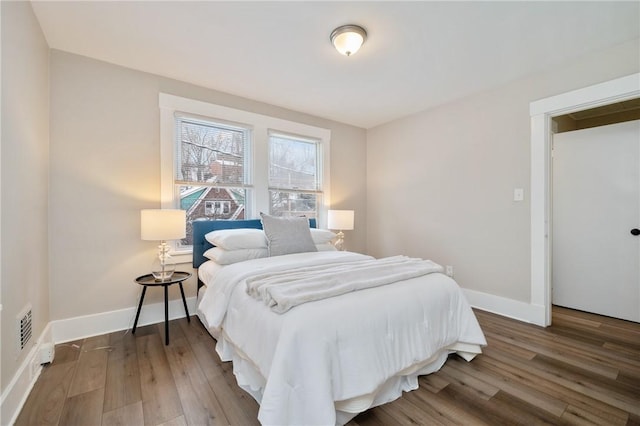 bedroom featuring visible vents, wood finished floors, and baseboards