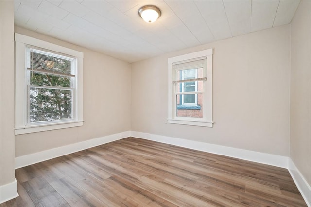 unfurnished room with baseboards and wood finished floors