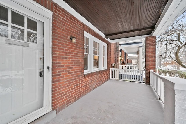 snow covered patio with a porch